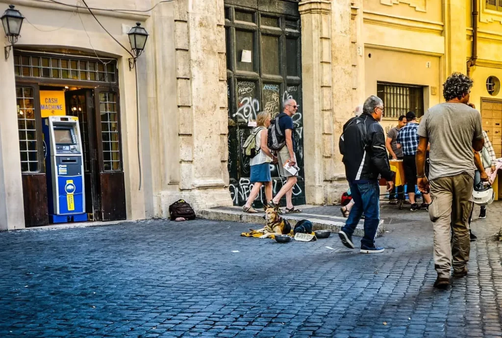 a pedestrian street with an atm and people walking nearby